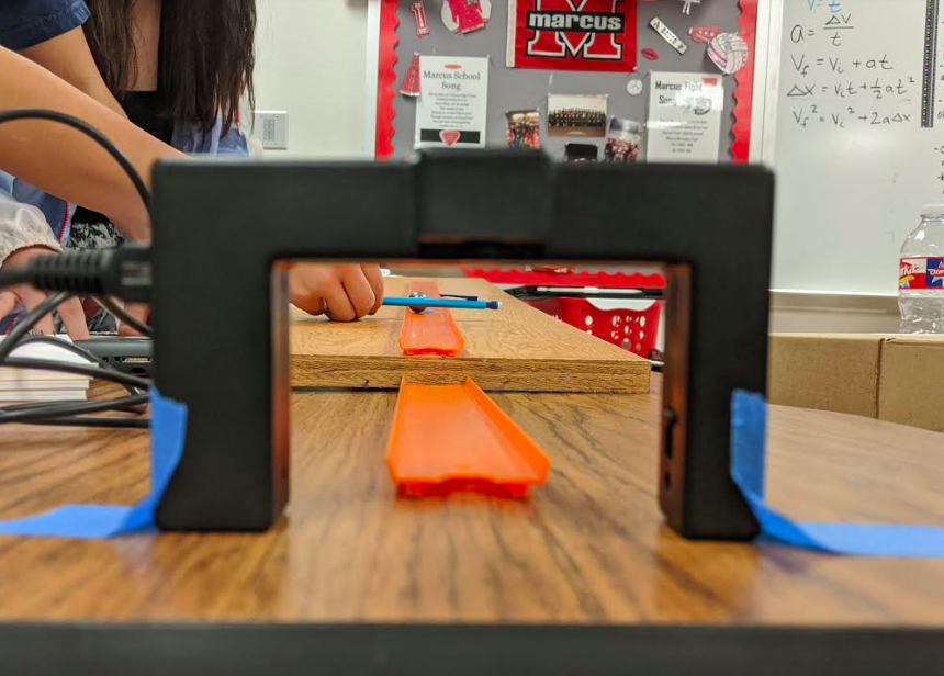 Junior Natalia Valdez steadies a small steel ball with her pencil before rolling it down a ramp in Kassandra Murphy's AP Physics class. Students performed multiple variations of the lab and analyzed the ball's velocity.