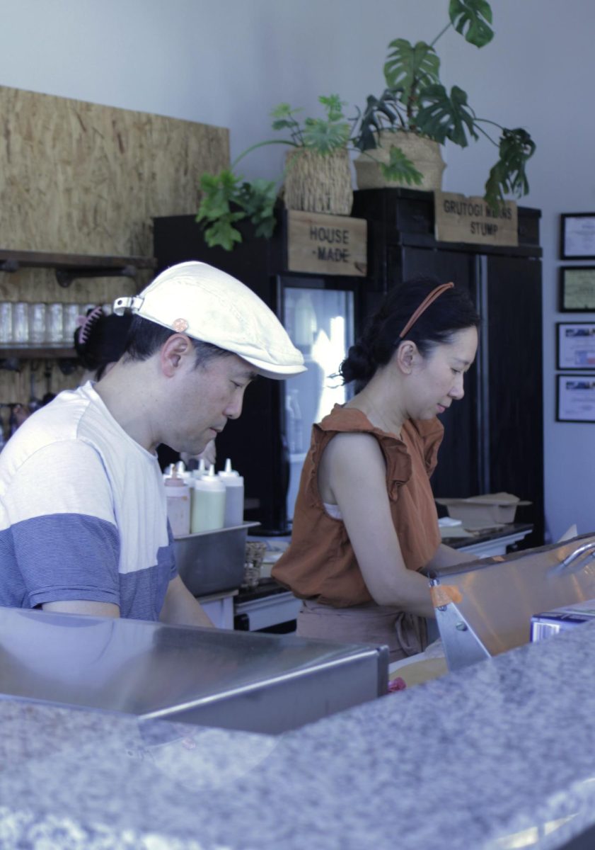 Eun and Danny make sandwiches for their next customers during a lunch rush.